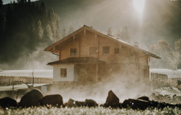 Dampfender Badeteich mit Chalet im Hintergrund. Herbsturlaub in &Ouml;sterreich