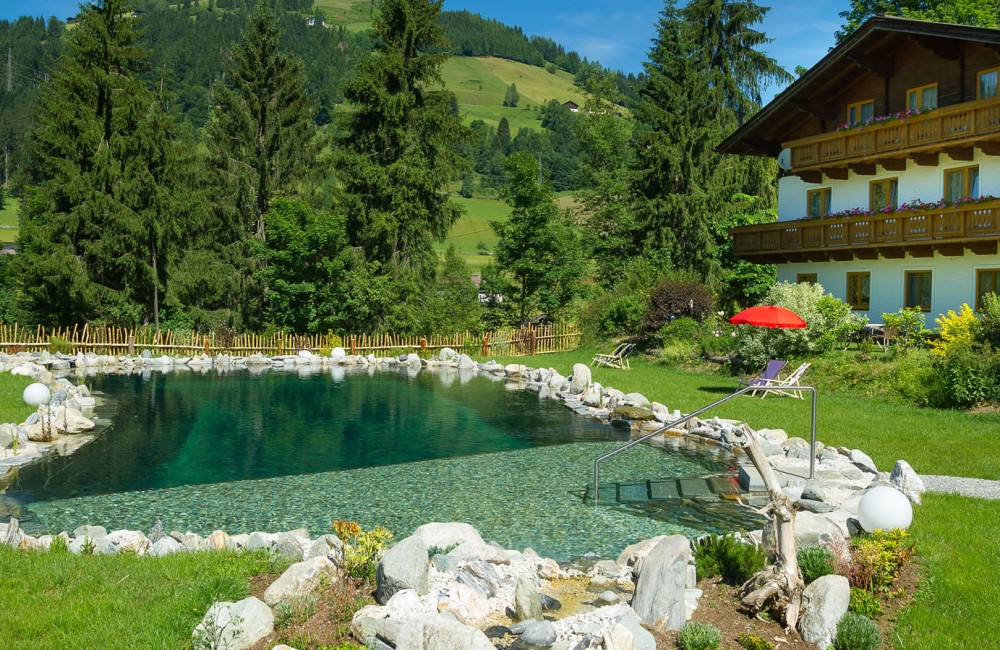 Naturbadeteich mit Appartements im Hintergrund, in Wagrain
