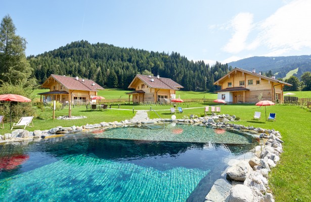 Naturbadeteich mit den 3 Rosen-Chalets im Hintergrund in Wagrain