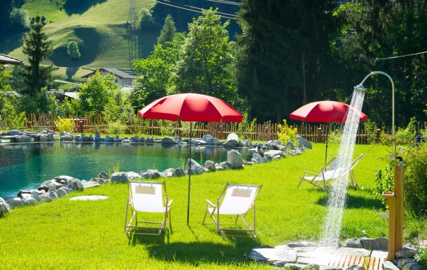 Sonnige Liegewiese mit Regendusche am Naturbadeteich